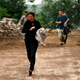 People run past a hillside alley which is at risk of landslide after an earthquake hit Ludian county of Zhaotong, Yunnan province August 3, 2014